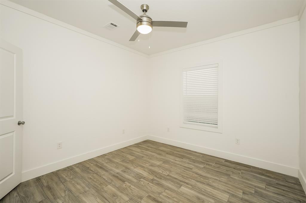 2003 East Overton Road Dallas, TX 75216 - Photo 14 of 16 an empty room with wooden floor and fan