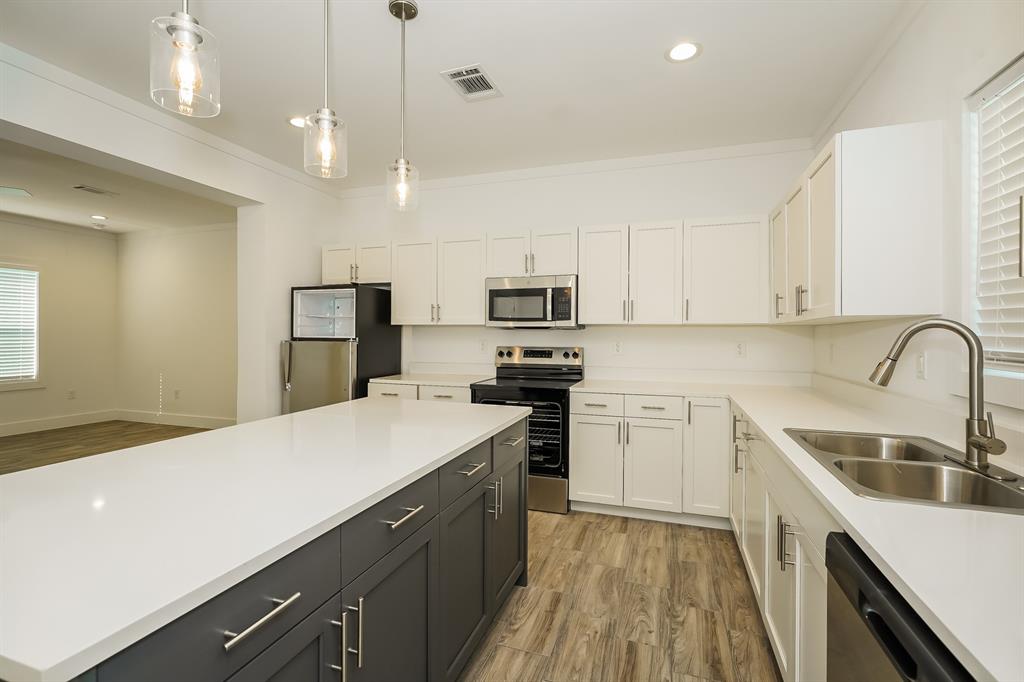2003 East Overton Road Dallas, TX 75216 - Photo 8 of 16 a kitchen with a sink a counter top space stainless steel appliances and cabinets