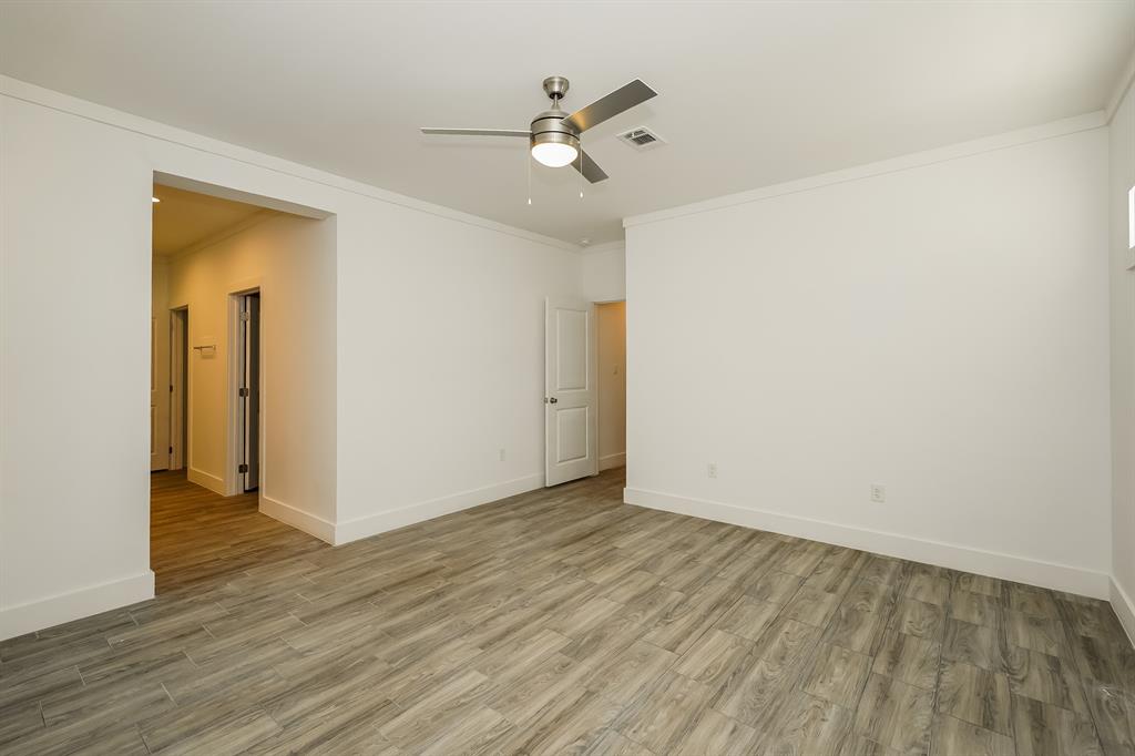 2003 East Overton Road Dallas, TX 75216 - Photo 10 of 16 an empty room with wooden floor and a ceiling fan