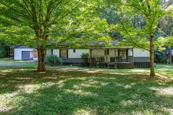 a view of a house with backyard and a tree