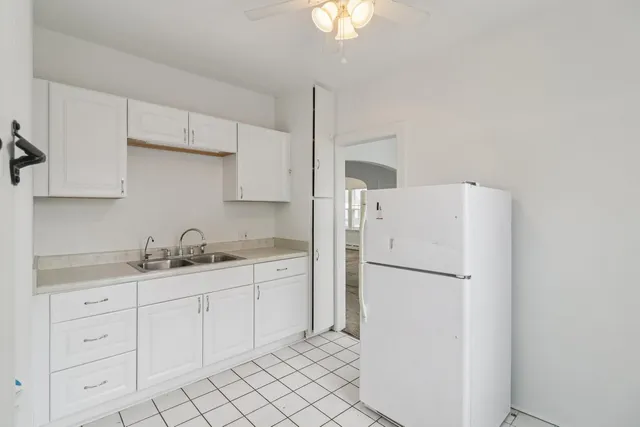 a kitchen with white cabinets and sink