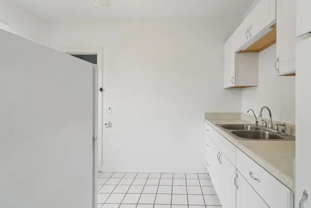 an empty room with windows and ceiling fan