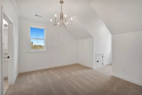 a view of an empty room with chandelier