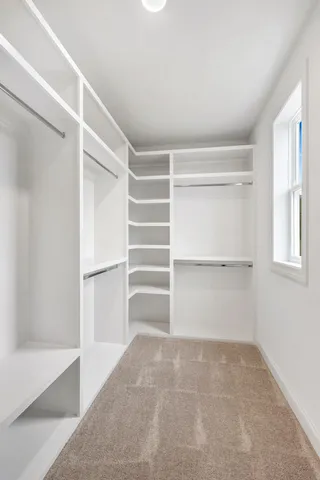 a view of walk in closet with empty racks