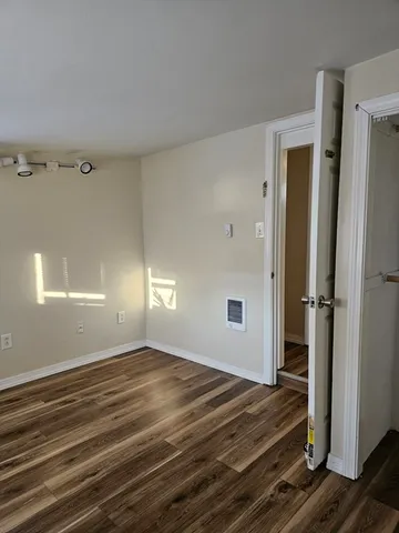a view of a room with wooden floor and window
