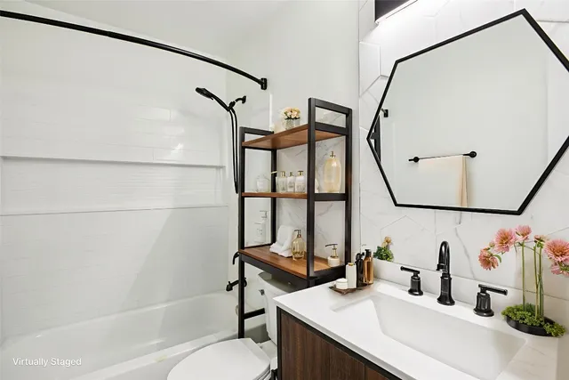 a bathroom with a sink vanity mirror and toilet