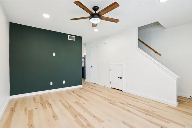 a view of a big room with wooden floor and a ceiling fan