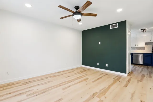 a view of a livingroom with a ceiling fan and kitchen space