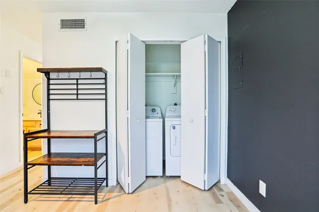 a view of a bathroom with a walk in closet and wooden floor