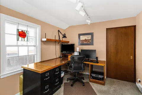 a view of a workspace with furniture and a window