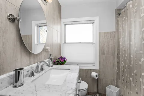 a bathroom with a toilet sink and mirror