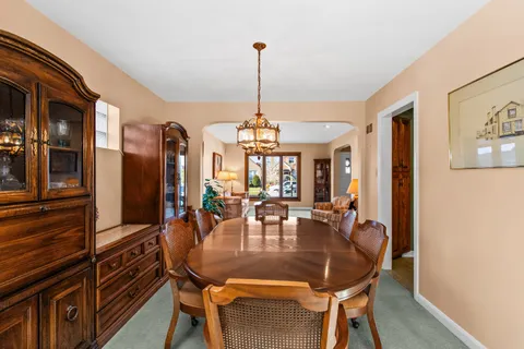 a dining room with furniture a chandelier and wooden floor