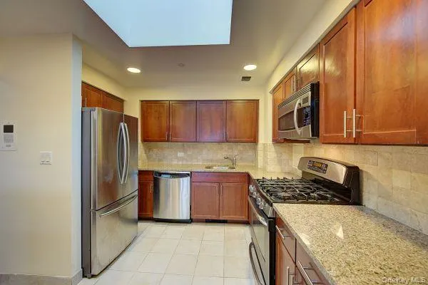 a kitchen with stainless steel appliances granite countertop a refrigerator stove a sink and dishwasher