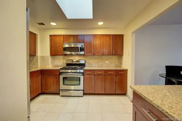 a kitchen with stainless steel appliances granite countertop a stove microwave and cabinets