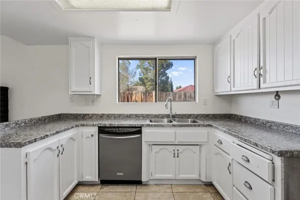 a kitchen with granite countertop white cabinets and white appliances