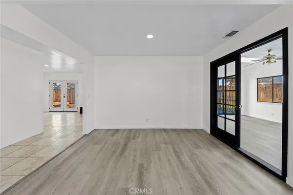 an empty room with wooden floor and window