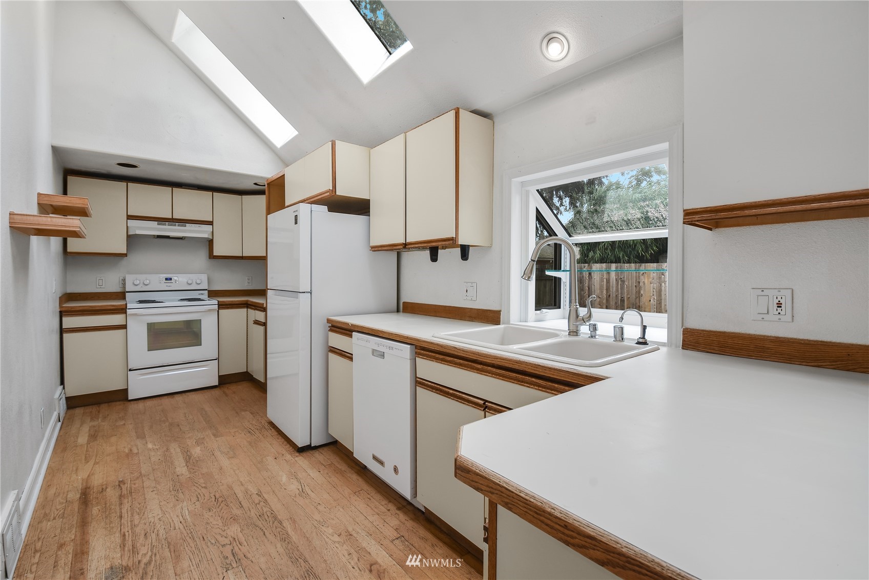 6422 Cady Road Everett, WA 98203 - Photo 7 of 21 a kitchen with stainless steel appliances a stove a sink dishwasher a refrigerator and white cabinets with wooden floor