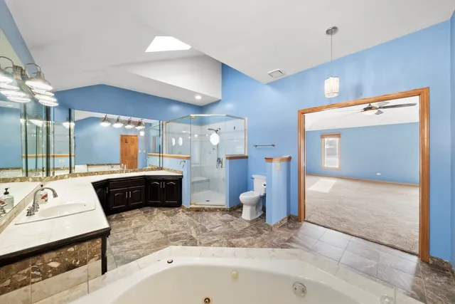 a bathroom with a tub sink and mirror