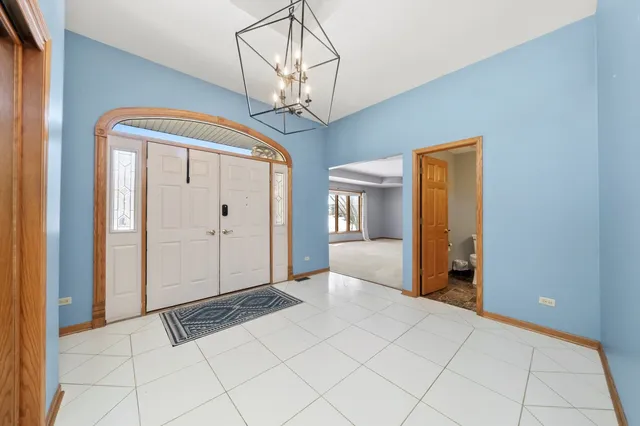 a view of a hallway with wooden floor and a chandelier