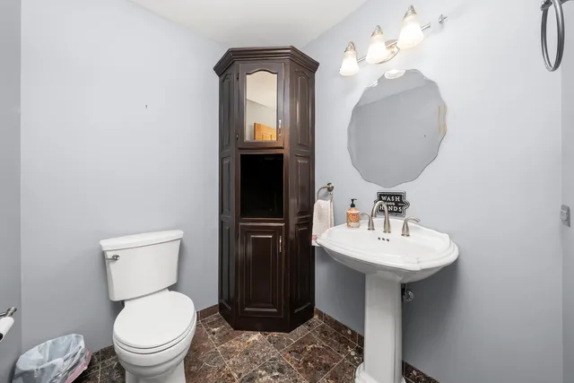 a bathroom with a toilet sink and mirror