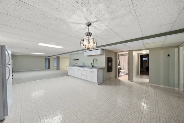 a large room with chandelier fan and windows