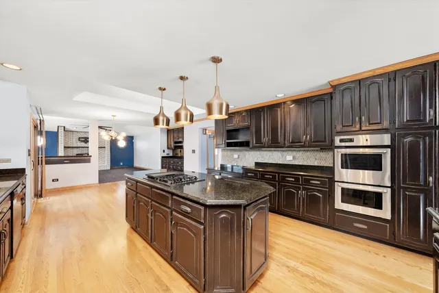 a kitchen with stainless steel appliances granite countertop a stove sink and cabinets