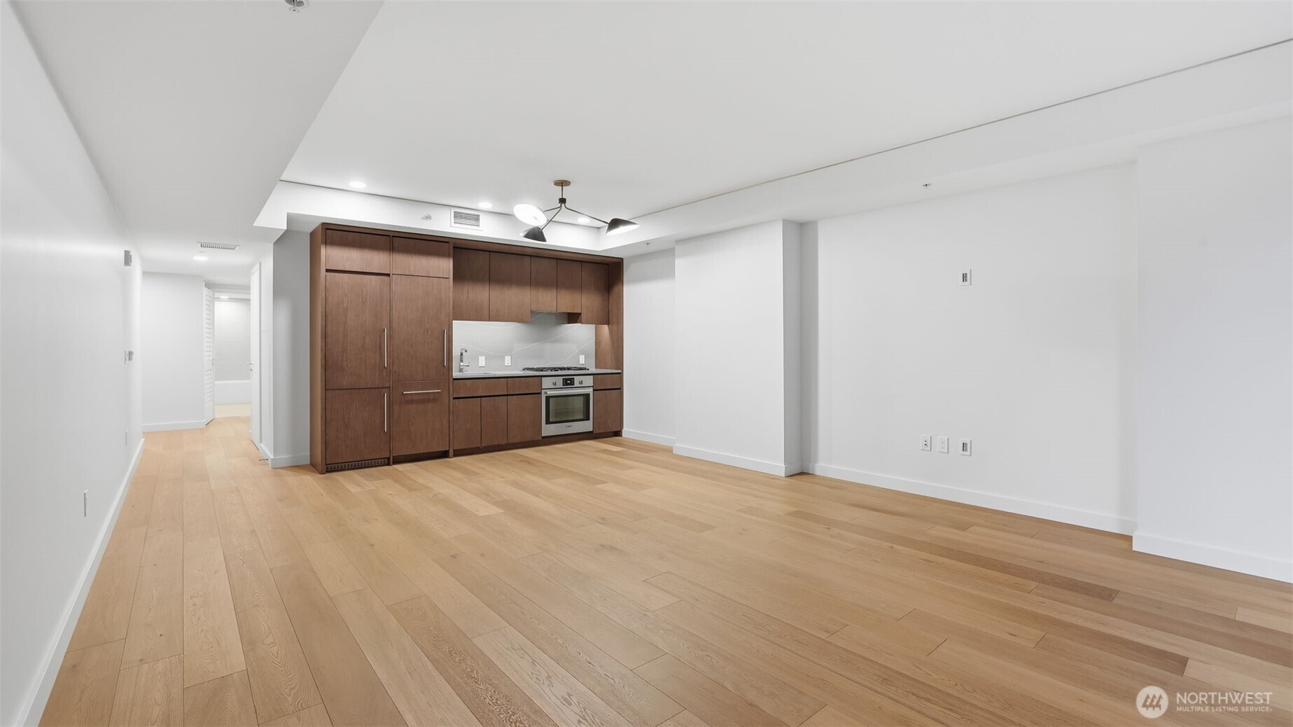 121 Stewart Street, Unit 905 Seattle, WA 98101 - Photo 7 of 37 a view of an empty room with a kitchen