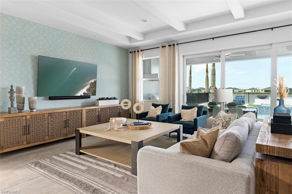 8775 Oceana Way Naples, FL 34114 - Photo 3 of 30 a living room with furniture a large window and a flat screen tv
