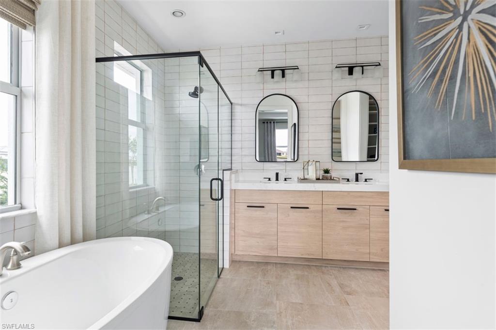 8775 Oceana Way Naples, FL 34114 - Photo 8 of 30 a bathroom with a double vanity sink mirror and bathtub
