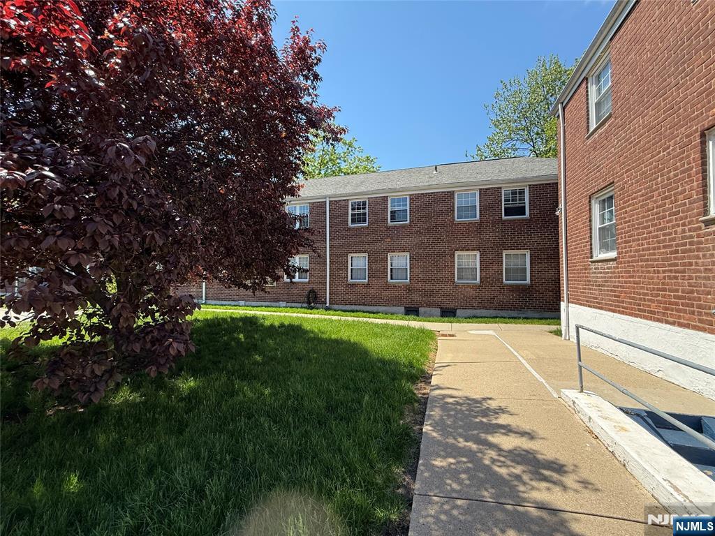 20 Clark Court Rutherford, NJ 07070 - Photo 26 of 29 a view of a yard in front of a brick house with a large tree