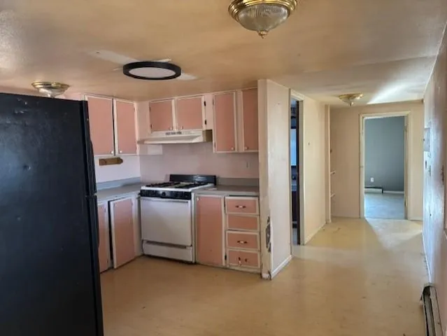 a kitchen with stainless steel appliances granite countertop a refrigerator and a stove top oven