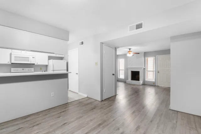 a kitchen with granite countertop a refrigerator and a stove top oven