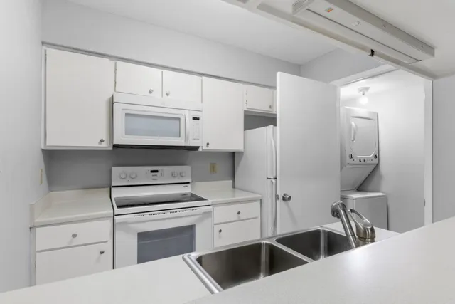 a kitchen with white cabinets and white appliances