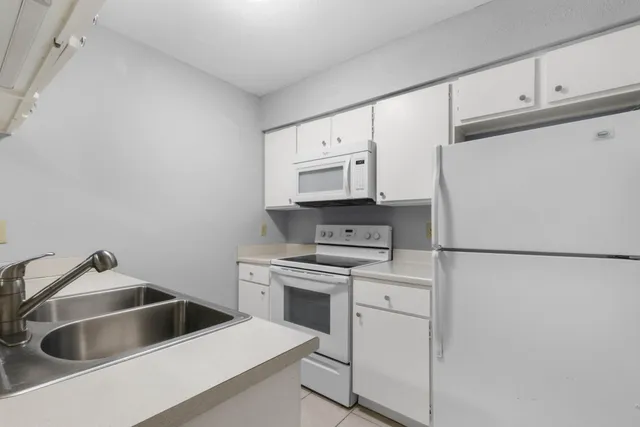 a kitchen with white cabinets and white appliances