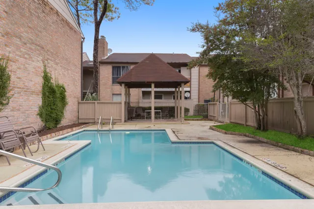 a view of a house with pool and sitting area