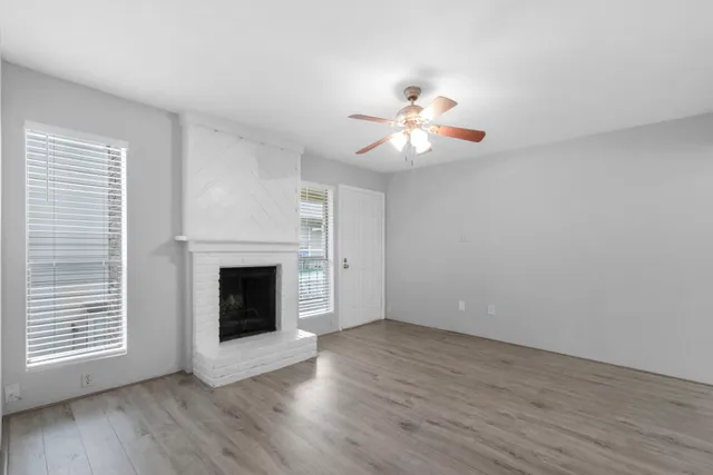 a view of an empty room with a fireplace and a window