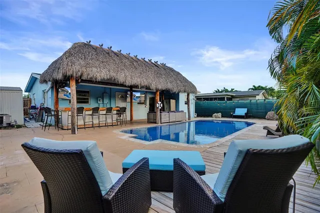 a view of a house and patio with couches chairs under an umbrella