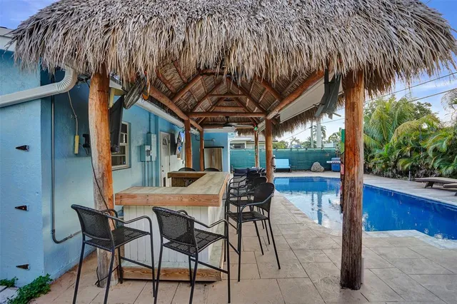 a view of a patio with table and chairs and potted plants with wooden floor