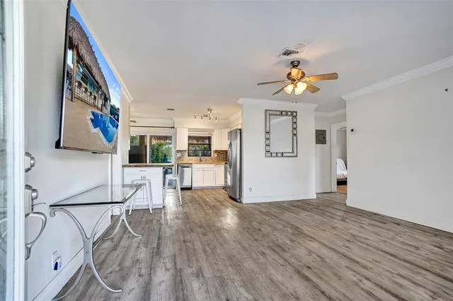 a view of a living room and kitchen with a wooden floor