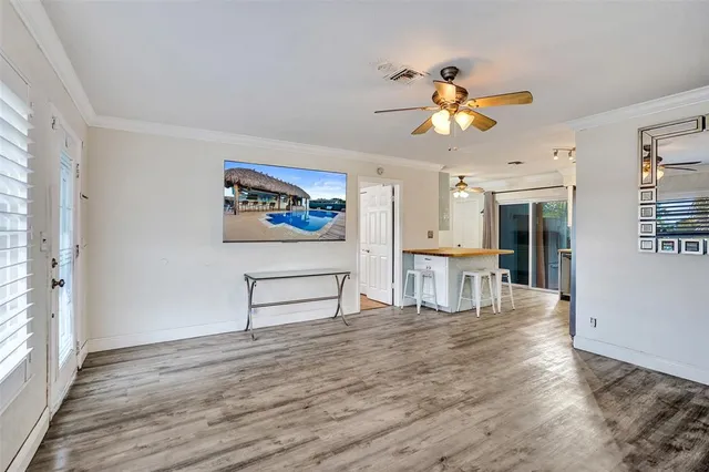 a view of a livingroom with wooden floor and a ceiling fan