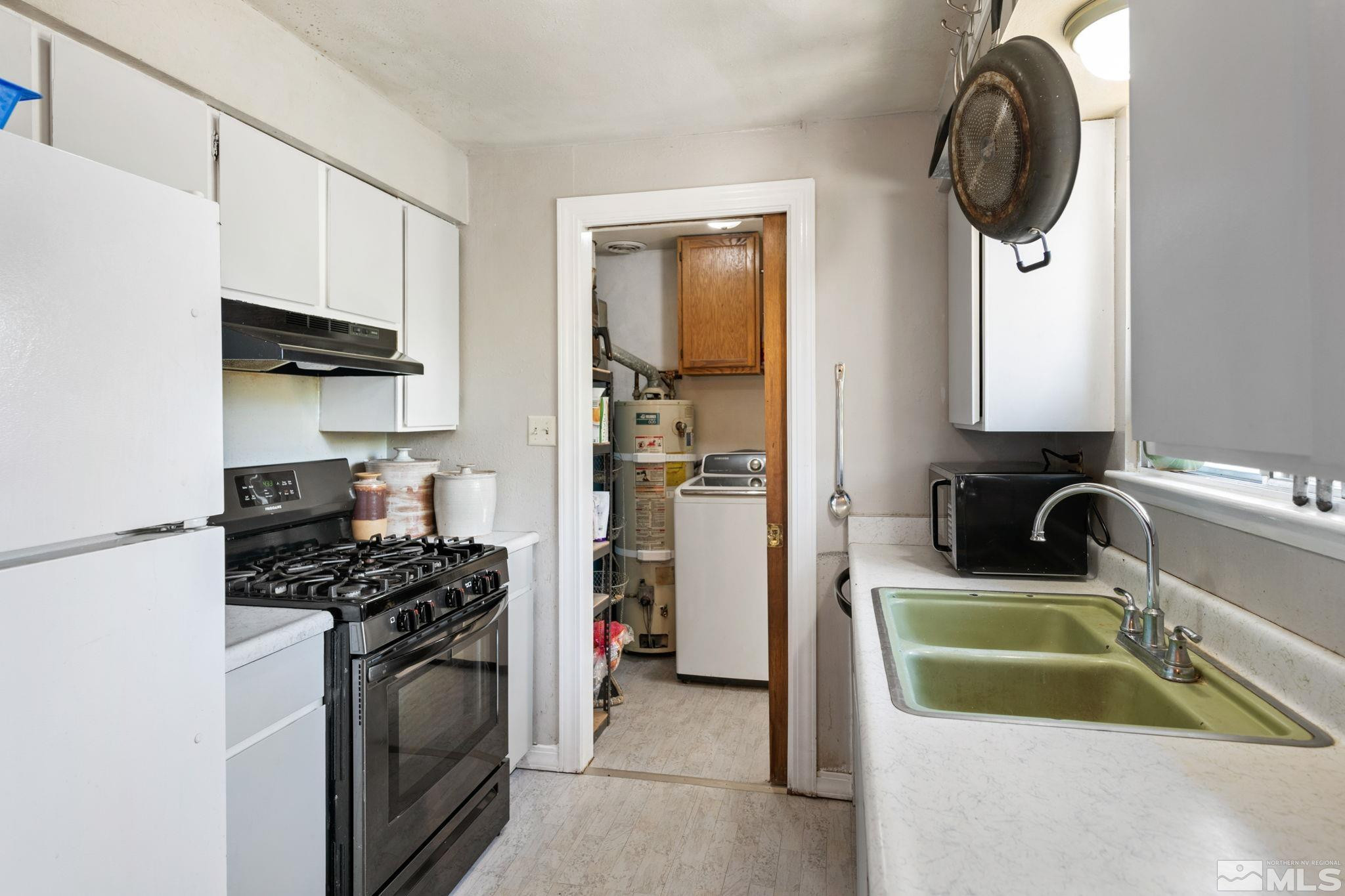 335 West Cedar Street Fernley, NV 89408 - Photo 13 of 26 a kitchen with stainless steel appliances a sink a stove and a refrigerator with wooden floor