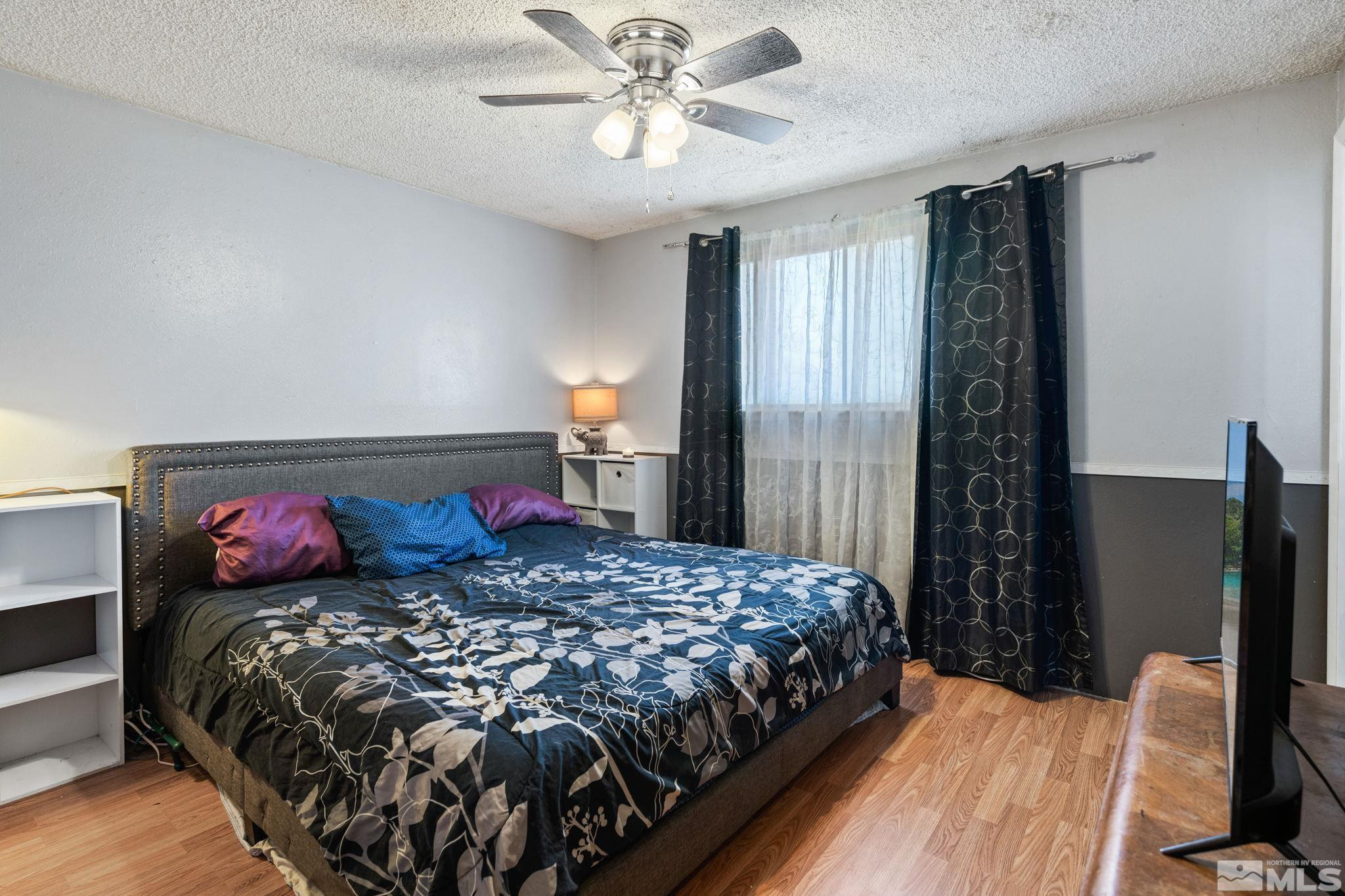 335 West Cedar Street Fernley, NV 89408 - Photo 16 of 26 a bedroom with a bed and a chandelier