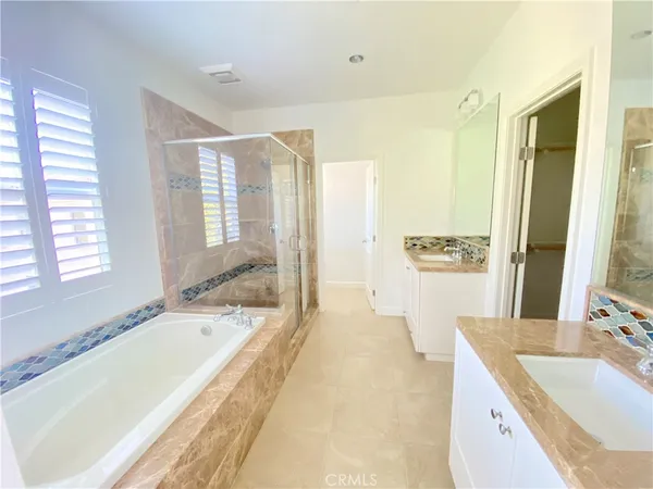 a spacious bathroom with a tub sink and mirror