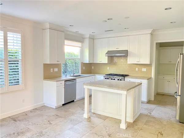 a kitchen with a stove a sink and a refrigerator