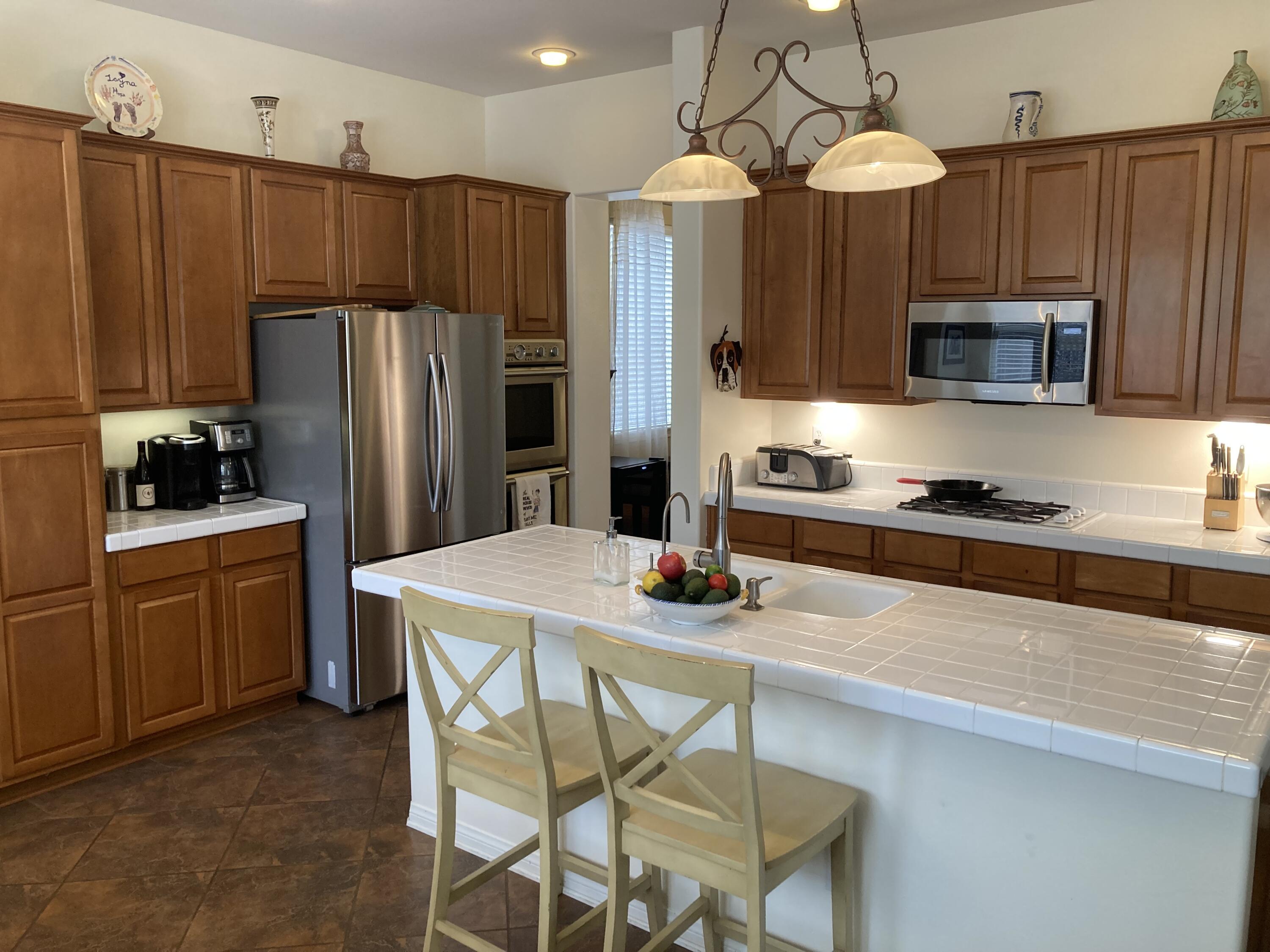 363 Quail Run Road Buellton, CA 93427 - Photo 11 of 25 a kitchen with kitchen island a refrigerator stove and microwave