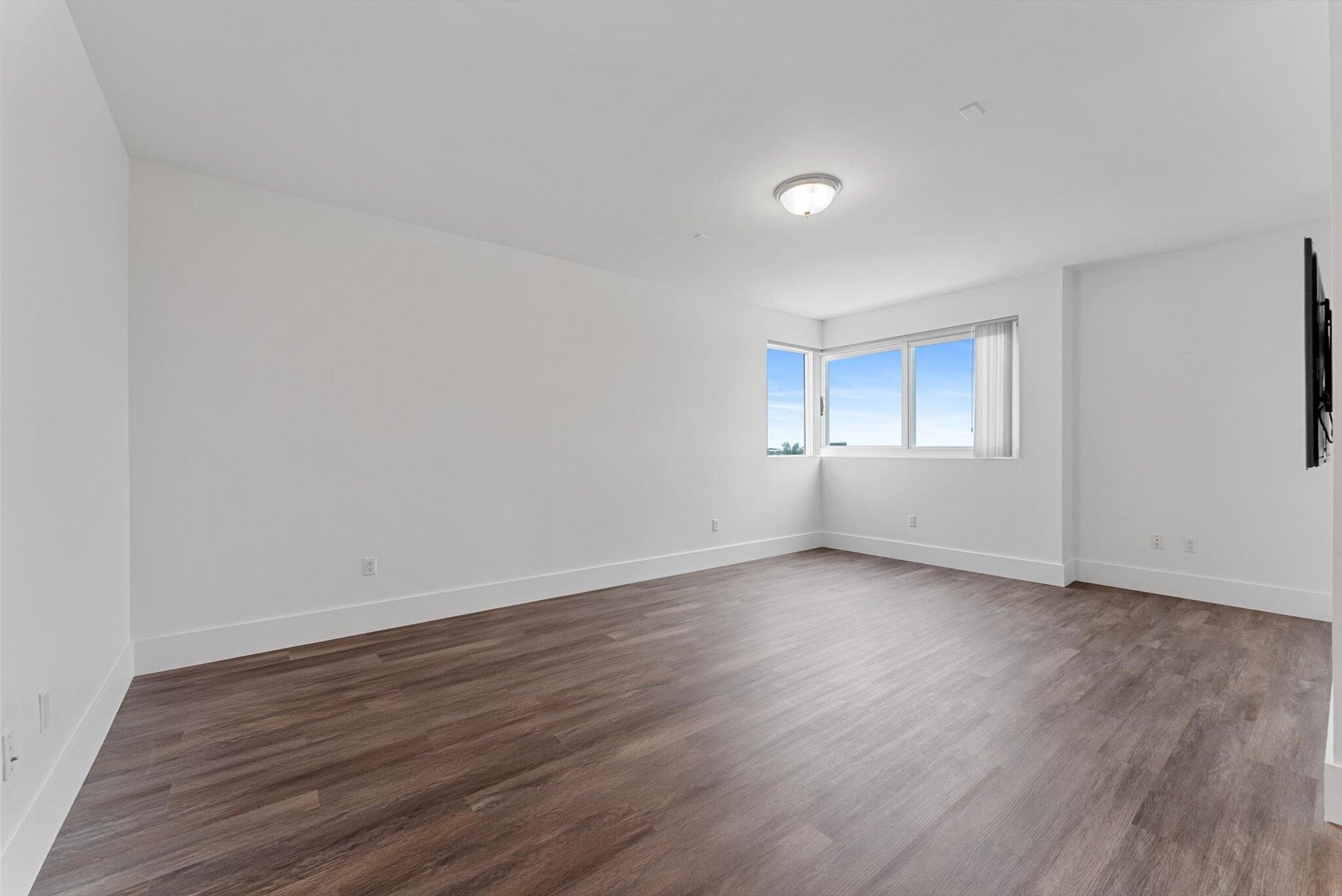 455 East Palmetto Park Road, Unit 6E Boca Raton, FL 33432 - Photo 11 of 28 a view of an empty room with wooden floor and window