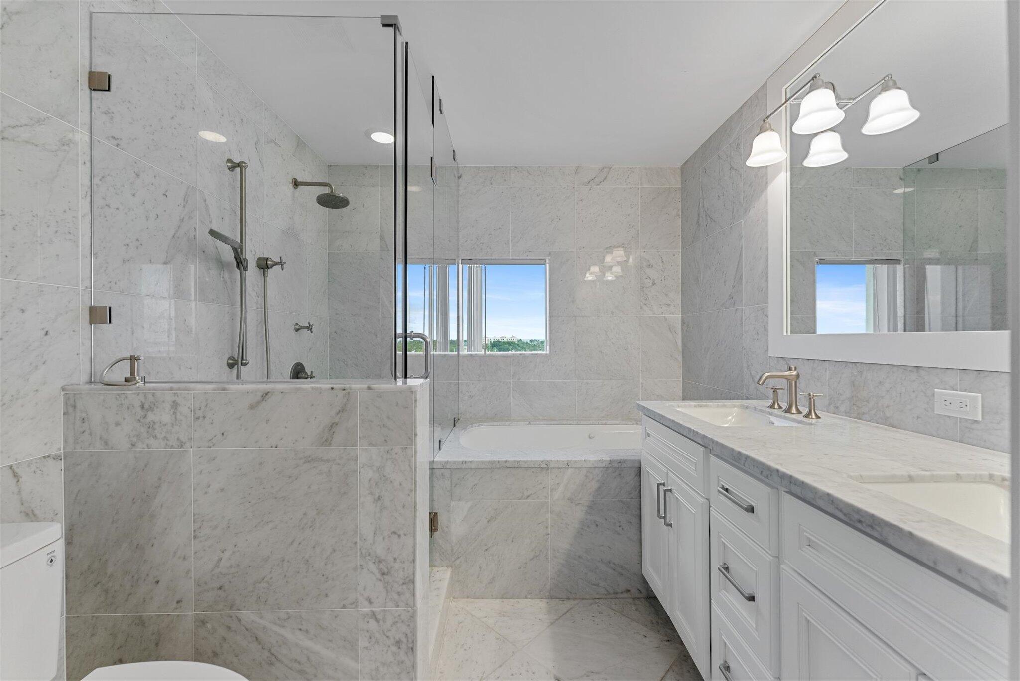 455 East Palmetto Park Road, Unit 6E Boca Raton, FL 33432 - Photo 14 of 28 a spacious bathroom with a granite countertop sink a mirror a shower and a bathtub