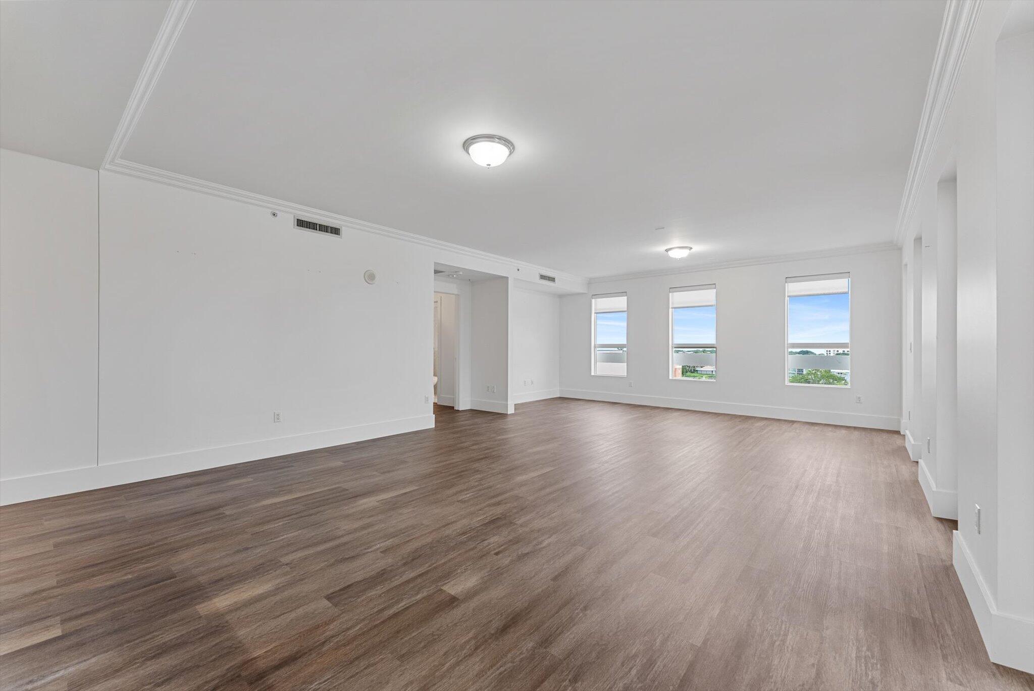 455 East Palmetto Park Road, Unit 6E Boca Raton, FL 33432 - Photo 6 of 28 an empty room with wooden floor and windows