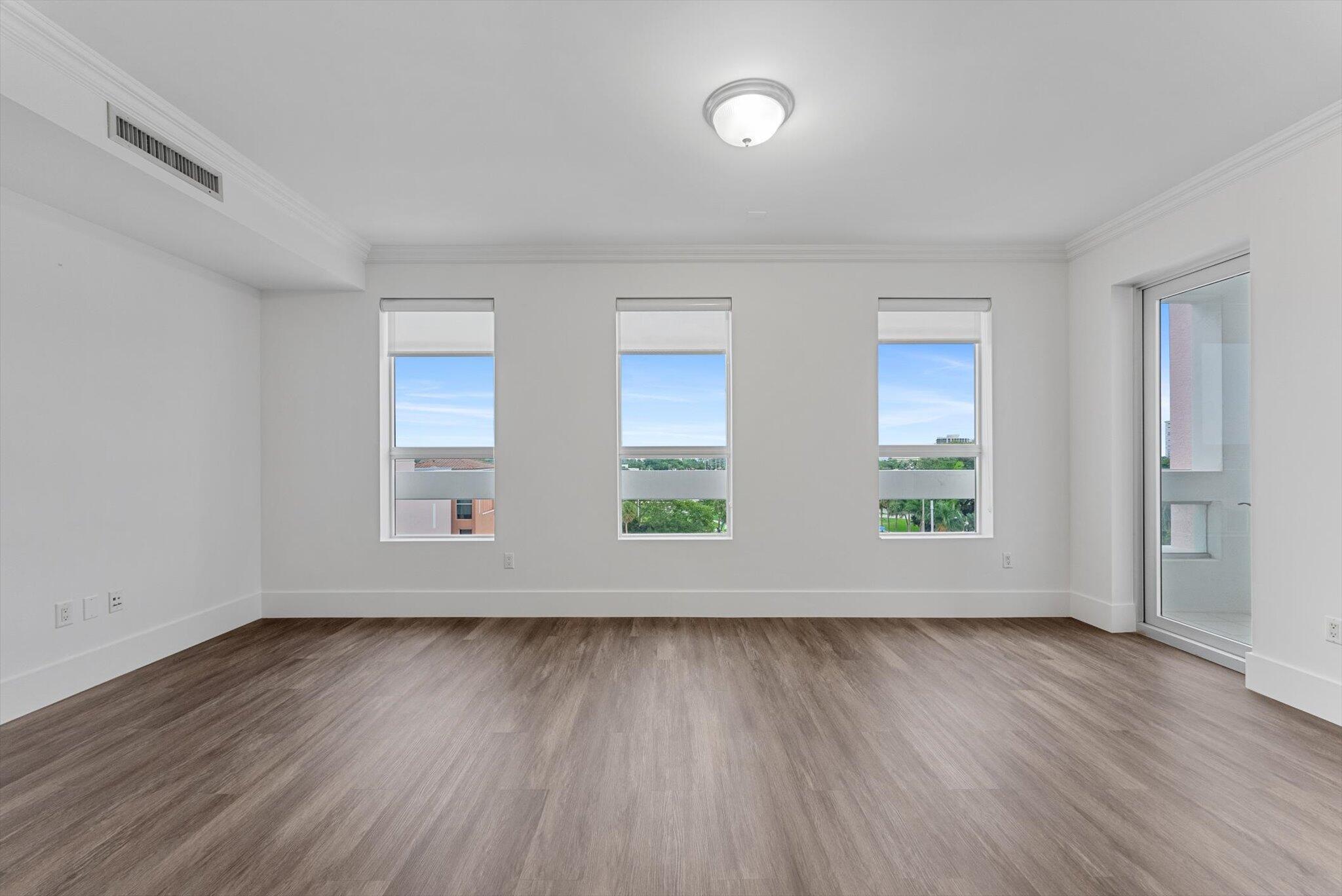 455 East Palmetto Park Road, Unit 6E Boca Raton, FL 33432 - Photo 9 of 28 an empty room with wooden floor and windows