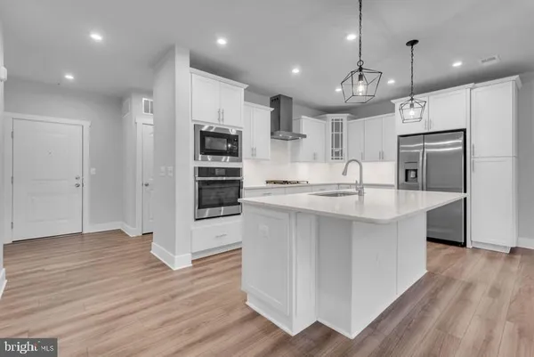 a kitchen with kitchen island a large counter top space appliances and cabinets